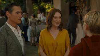 Movie still from “After the Wedding” (2019), directed by Bart Freundlich – A woman in a yellow top standing in front of a crowd; Medium shot, Over the shoulder angle