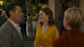 Movie still from “After the Wedding” (2019), directed by Bart Freundlich – A woman in a yellow top talking to two men; Medium shot, Over the shoulder angle