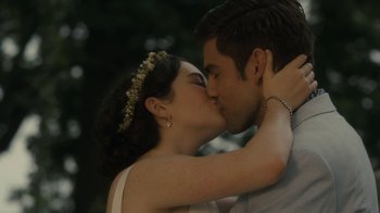 Movie still from “After the Wedding” (2019), directed by Bart Freundlich – A man and a woman kissing each other in front of trees; Close Up shot, Over the shoulder angle