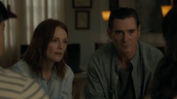Movie still from “After the Wedding” (2019), directed by Bart Freundlich – A man and a woman sitting next to each other in a room; Medium shot, Over the shoulder angle