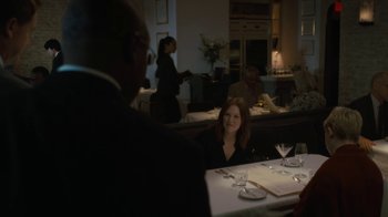 Movie still from “After the Wedding” (2019), directed by Bart Freundlich – A woman sitting at a table with a glass of wine; Medium shot, Over the shoulder angle