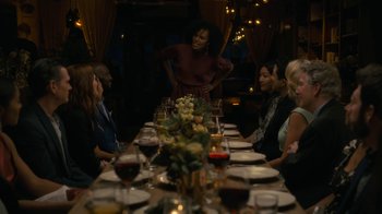 Movie still from “After the Wedding” (2019), directed by Bart Freundlich – A group of people sitting around a table with wine glasses on it; Medium shot, Over the shoulder angle