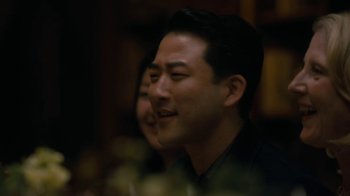 Movie still from “After the Wedding” (2019), directed by Bart Freundlich – A person smiling at a party; Close Up shot, Over the shoulder angle