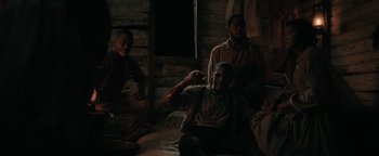 Movie still from “Alice” (2022), directed by Krystin Ver Linden – A group of men sitting in a dark room; Medium shot, Over the shoulder angle