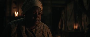 Movie still from “Alice” (2022), directed by Krystin Ver Linden – An older woman wearing a headscarf looking at the camera; Close Up shot, Over the shoulder angle