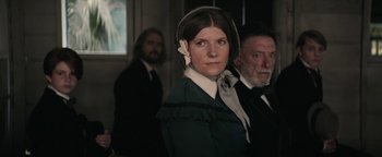 Movie still from “Alice” (2022), directed by Krystin Ver Linden – A woman in a green dress and a man in a suit and tie; Medium shot, Over the shoulder angle
