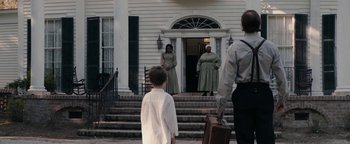 Movie still from “Alice” (2022), directed by Krystin Ver Linden – Two women and a boy stand in front of a house; Wide shot, Over the shoulder angle