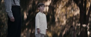 Movie still from “Alice” (2022), directed by Krystin Ver Linden – A young boy standing in front of a tree; Medium shot, Low angle