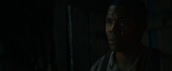 Movie still from “Alice” (2022), directed by Krystin Ver Linden – A man standing in the dark looking at the camera; Close Up shot, Over the shoulder angle