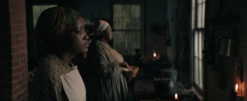 Movie still from “Alice” (2022), directed by Krystin Ver Linden – Two people standing next to each other in a room; Medium shot, Over the shoulder angle