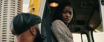 Movie still from “Alice” (2022), directed by Krystin Ver Linden – A woman standing next to a man in a yellow bus; Close Up shot, Over the shoulder angle