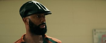 Movie still from “Alice” (2022), directed by Krystin Ver Linden – A man with a beard wearing a green hat; Close Up shot, Over the shoulder angle