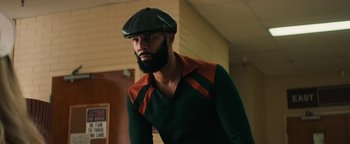 Movie still from “Alice” (2022), directed by Krystin Ver Linden – A man with a beard wearing a hat and a green shirt; Medium shot, Low angle