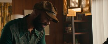 Movie still from “Alice” (2022), directed by Krystin Ver Linden – A man wearing a hat and a green shirt; Medium shot, Over the shoulder angle