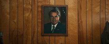 Movie still from “Alice” (2022), directed by Krystin Ver Linden – A picture of president richard m; Close Up shot, Low angle