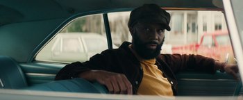 Movie still from “Alice” (2022), directed by Krystin Ver Linden – A man sitting in the back seat of a car; Close Up shot, Over the shoulder angle