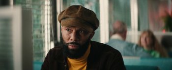 Movie still from “Alice” (2022), directed by Krystin Ver Linden – A man with a beard wearing a brown hat; Close Up shot, Over the shoulder angle