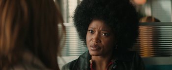 Movie still from “Alice” (2022), directed by Krystin Ver Linden – A person with a black afro; Close Up shot, Over the shoulder angle