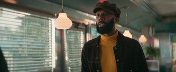 Movie still from “Alice” (2022), directed by Krystin Ver Linden – A man with a goatee and a beard wearing a hat; Medium shot, Low angle