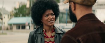 Movie still from “Alice” (2022), directed by Krystin Ver Linden – A woman with a big afro talking to a bearded man; Close Up shot, Over the shoulder angle