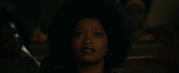 Movie still from “Alice” (2022), directed by Krystin Ver Linden – A person with a black afro; Close Up shot, Low angle
