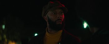 Movie still from “Alice” (2022), directed by Krystin Ver Linden – A man with a beard wearing a hat and a jacket; Close Up shot, Low angle