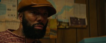 Movie still from “Alice” (2022), directed by Krystin Ver Linden – A man with a beard wearing a brown hat; Close Up shot, Over the shoulder angle