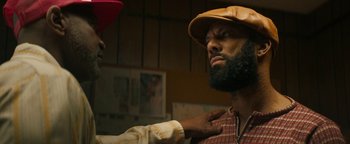 Movie still from “Alice” (2022), directed by Krystin Ver Linden – A man with a beard is getting his beard trimmed; Close Up shot, Over the shoulder angle