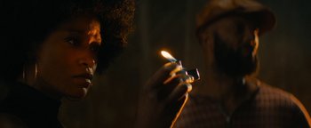 Movie still from “Alice” (2022), directed by Krystin Ver Linden – A man lighting a cigarette in a dark room; Extreme Close Up shot, Over the shoulder angle