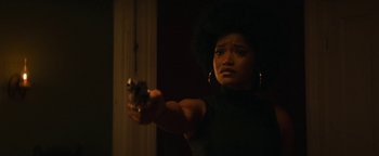 Movie still from “Alice” (2022), directed by Krystin Ver Linden – A woman holding a gun in a dark room; Close Up shot, Low angle