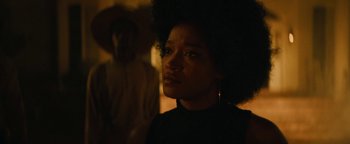 Movie still from “Alice” (2022), directed by Krystin Ver Linden – A woman in a black shirt is looking at the camera; Close Up shot, Over the shoulder angle