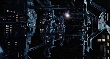 Movie still from “Aliens” (1986), directed by James Cameron – A view of a space station in the night sky; Extreme Wide shot, Overhead angle