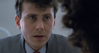 Movie still from “Aliens” (1986), directed by James Cameron – A person wearing a suit and tie; Close Up shot, Over the shoulder angle