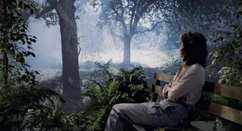 Movie still from “Aliens” (1986), directed by James Cameron – A man sitting on a park bench in the woods; Wide shot, High angle