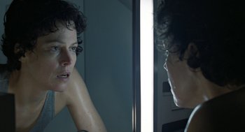 Movie still from “Aliens” (1986), directed by James Cameron – A woman looking in the mirror in front of a mirror; Close Up shot, Over the shoulder angle