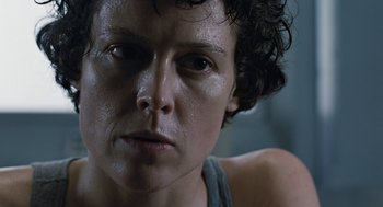 Movie still from “Aliens” (1986), directed by James Cameron – A person's face in a dark room; Close Up shot, Low angle
