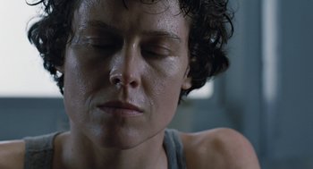 Movie still from “Aliens” (1986), directed by James Cameron – A person with eyes closed; Close Up shot, Low angle