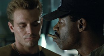 Movie still from “Aliens” (1986), directed by James Cameron – A man with a cigar in his mouth next to another man; Close Up shot, Over the shoulder angle