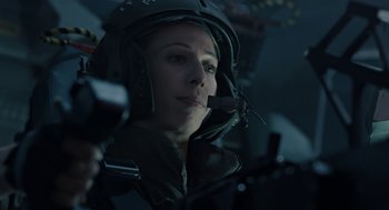 Movie still from “Aliens” (1986), directed by James Cameron – A woman wearing a helmet is sitting in a helicopter cockpit; Close Up shot, Low angle