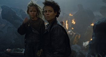 Movie still from “Aliens” (1986), directed by James Cameron – Two young children standing in front of a fire pit; Medium shot, Low angle