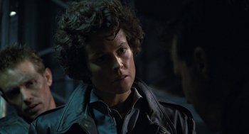 Movie still from “Aliens” (1986), directed by James Cameron – A man with curly hair wearing a leather jacket; Close Up shot, Over the shoulder angle