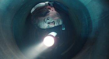 Movie still from “Aliens” (1986), directed by James Cameron – A man with a flashlight looking into a tunnel; Close Up shot, Overhead angle