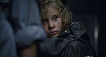 Movie still from “Aliens” (1986), directed by James Cameron – A young girl looking at the camera while wearing a black jacket; Close Up shot, Over the shoulder angle