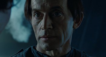 Movie still from “Aliens” (1986), directed by James Cameron – A man's face in a dark room; Close Up shot, Low angle