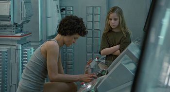 Movie still from “Aliens” (1986), directed by James Cameron – A woman and a girl are looking at something in a box; Medium shot, Over the shoulder angle