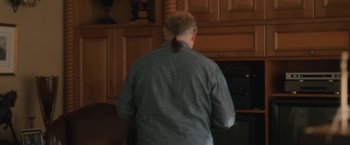 Movie still from “Aline” (2020), directed by Valérie Lemercier – A man standing in front of an open oven; Medium shot, Over the shoulder angle