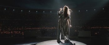 A woman is singing on a stage in front of a crowd