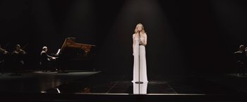 A woman standing on a stage holding a microphone