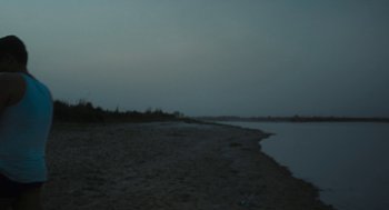 Movie still from “All That Breathes” (2022), directed by Shaunak Sen – A view of a body of water at night; Extreme Wide shot, Low angle