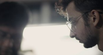Movie still from “All That Breathes” (2022), directed by Shaunak Sen – A person wearing glasses; Extreme Close Up shot, Over the shoulder angle